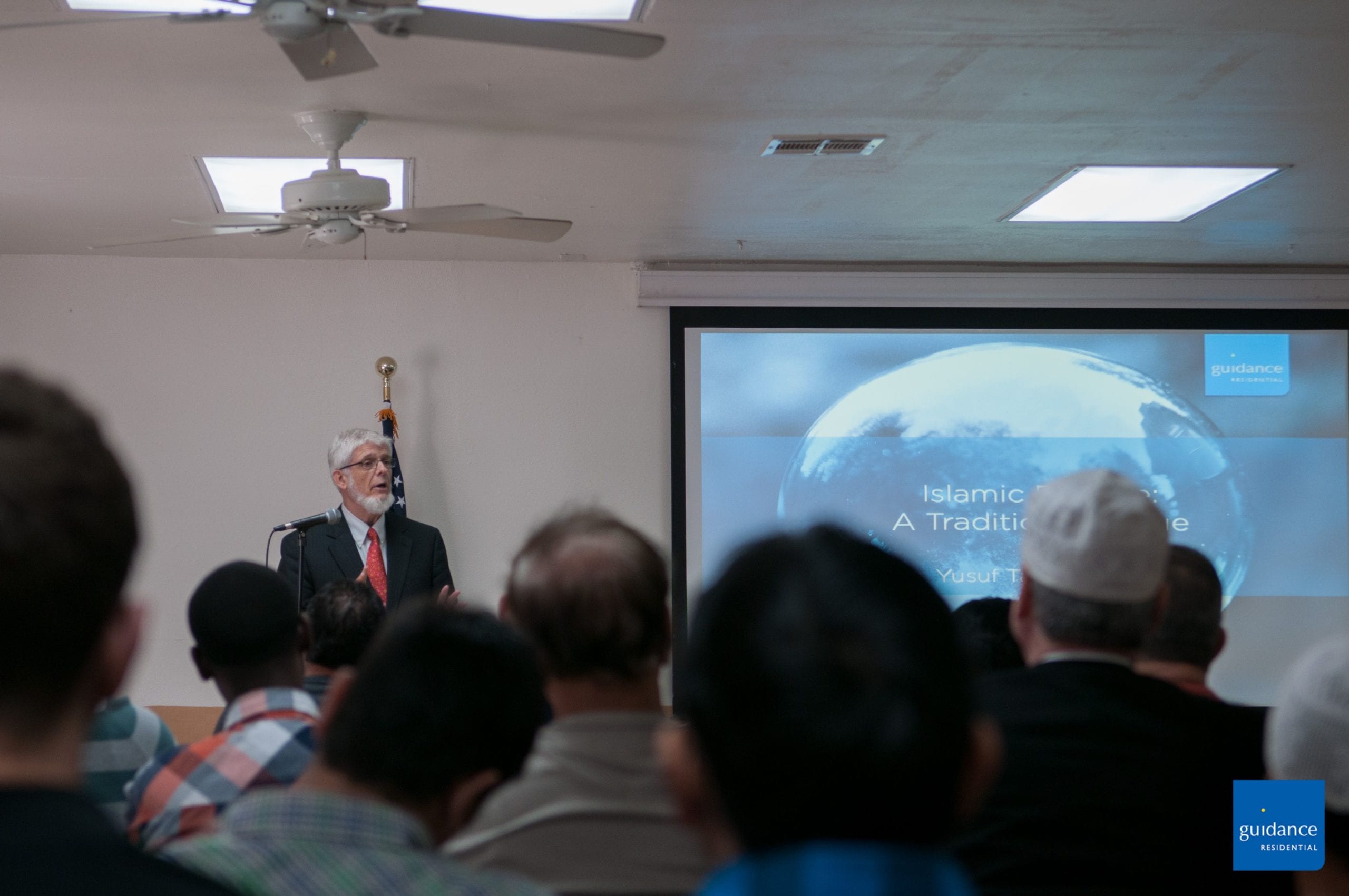 man speaking in front of an adult class