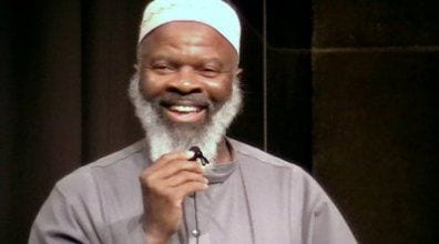 Imam Siraj Wahhaj smiling talkign into microphone