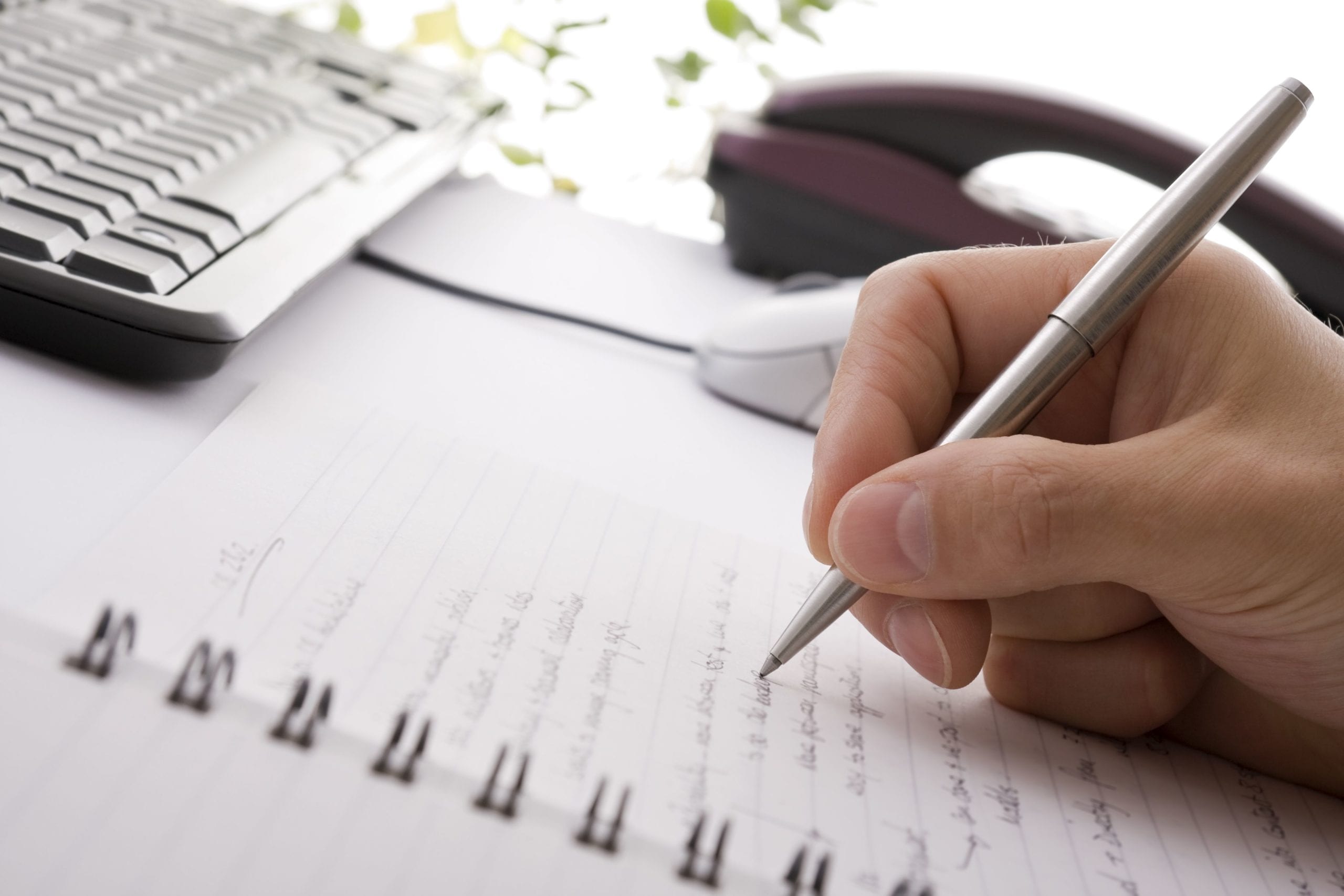 person writing on notebook