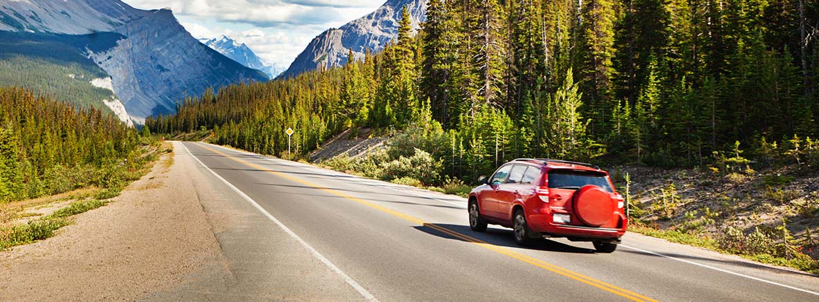 An Image of a red SUV driving in a highway