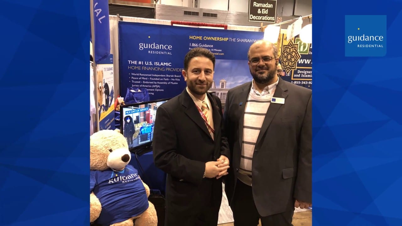two men standing at a guidance trade show booth